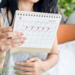 Mulher checando menstruação atrasada no calendário